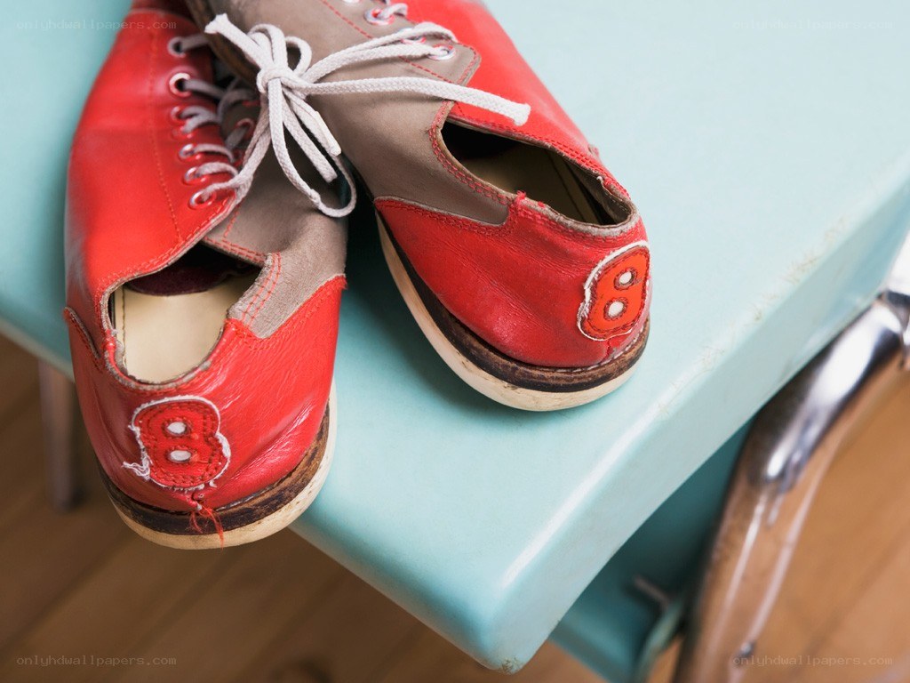 Red bowling shoes on a bench