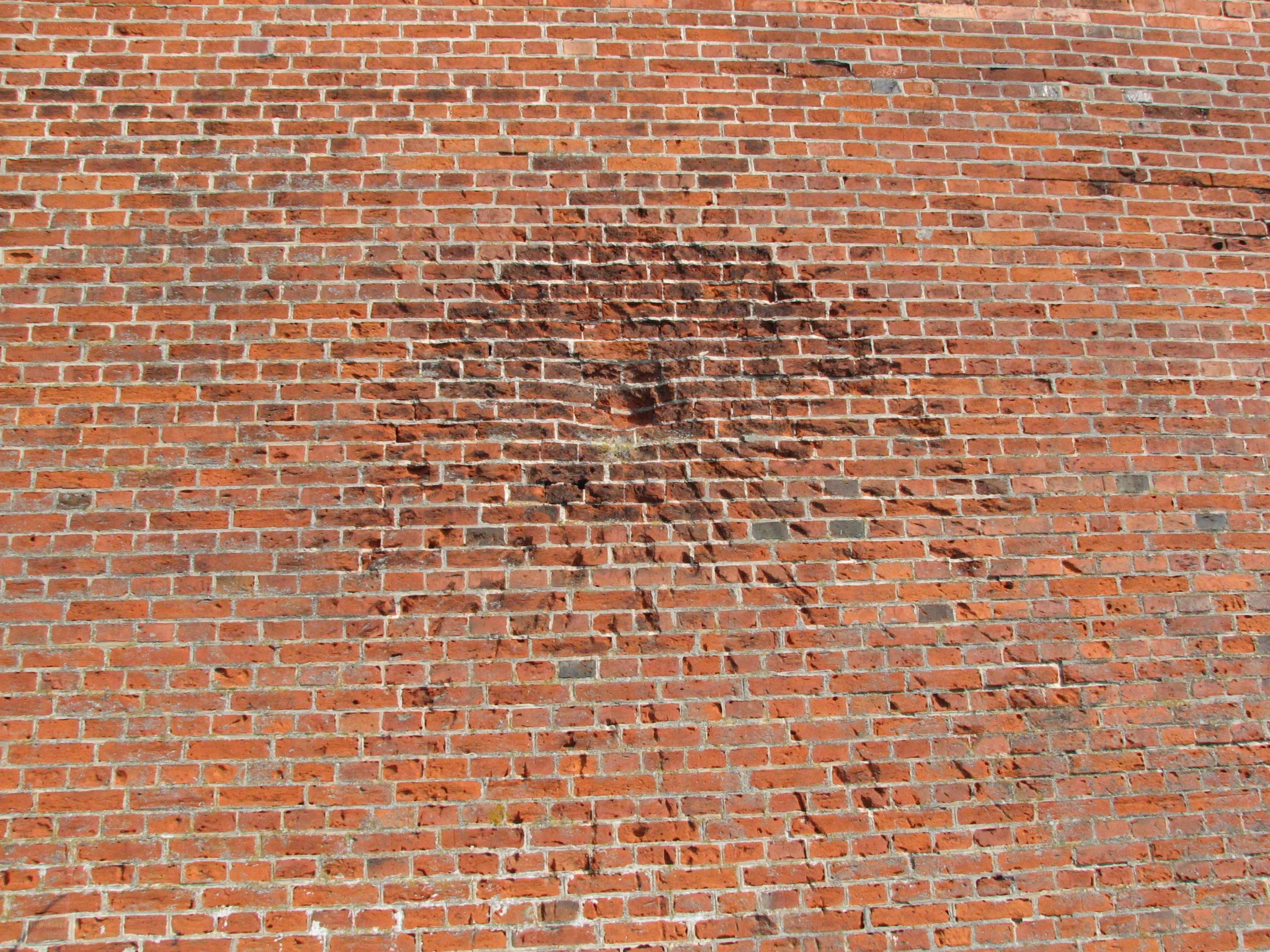 red brick wall with stains