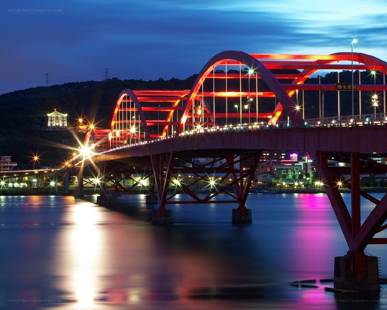 Red bridge at night over river