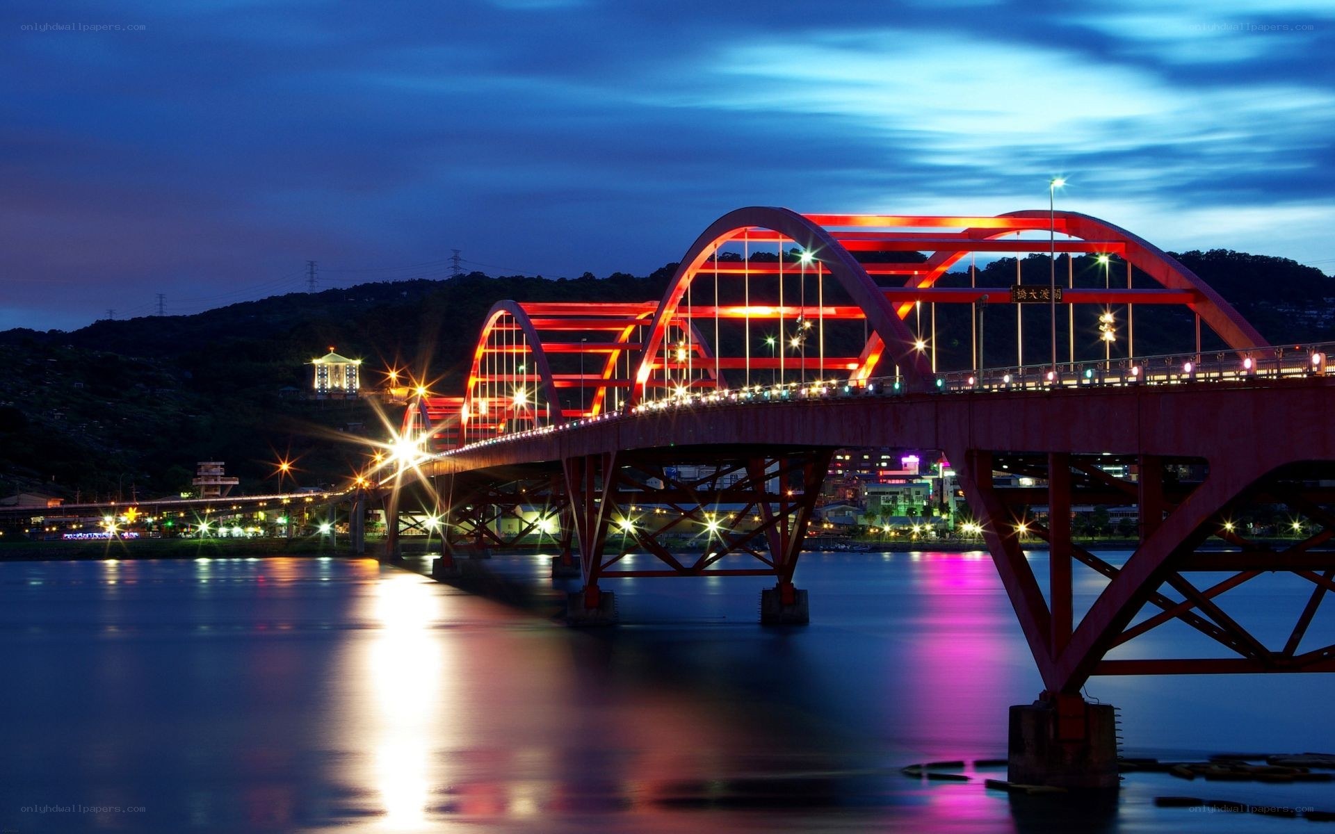 Red bridge at night over river