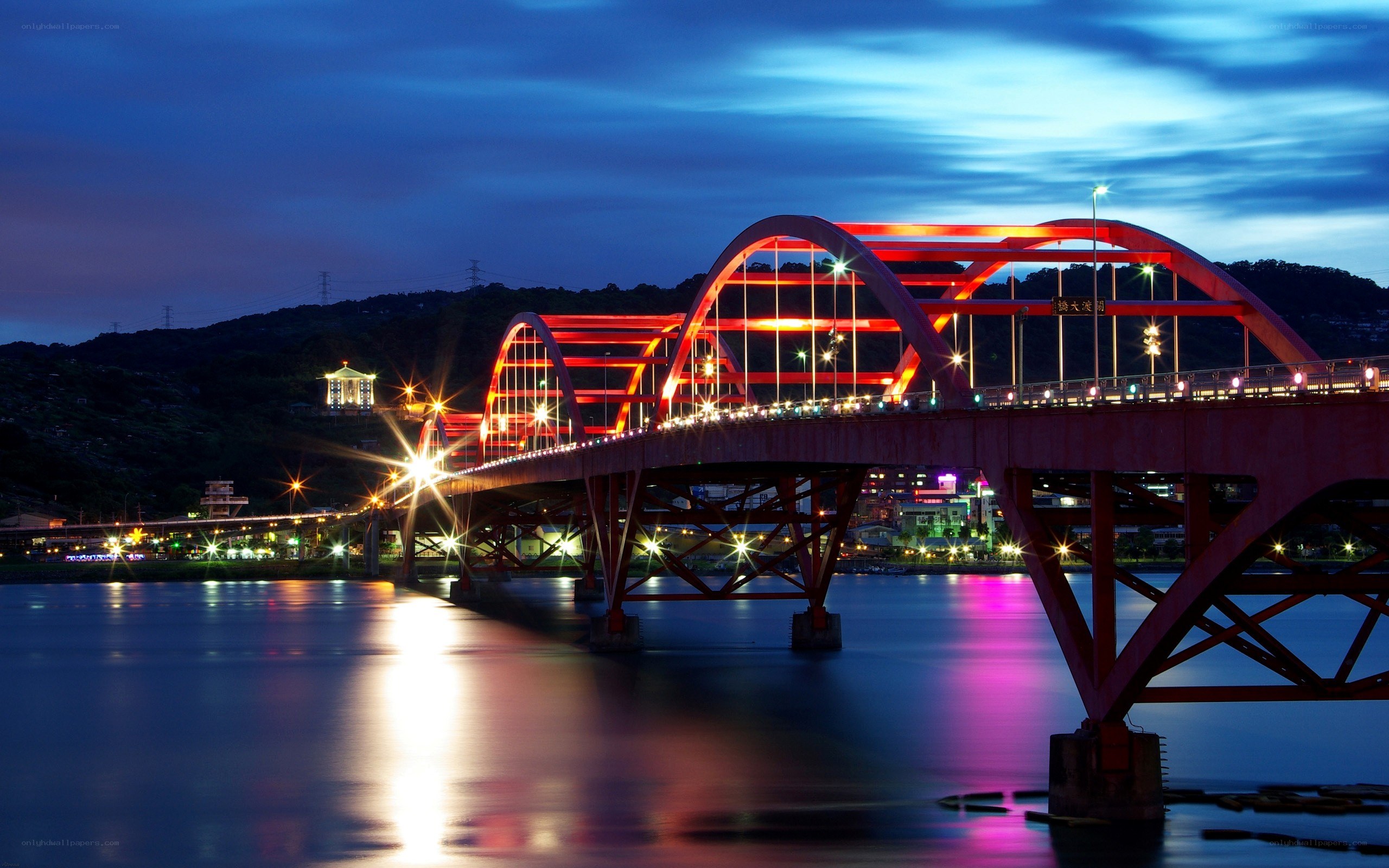 Red bridge at night over river