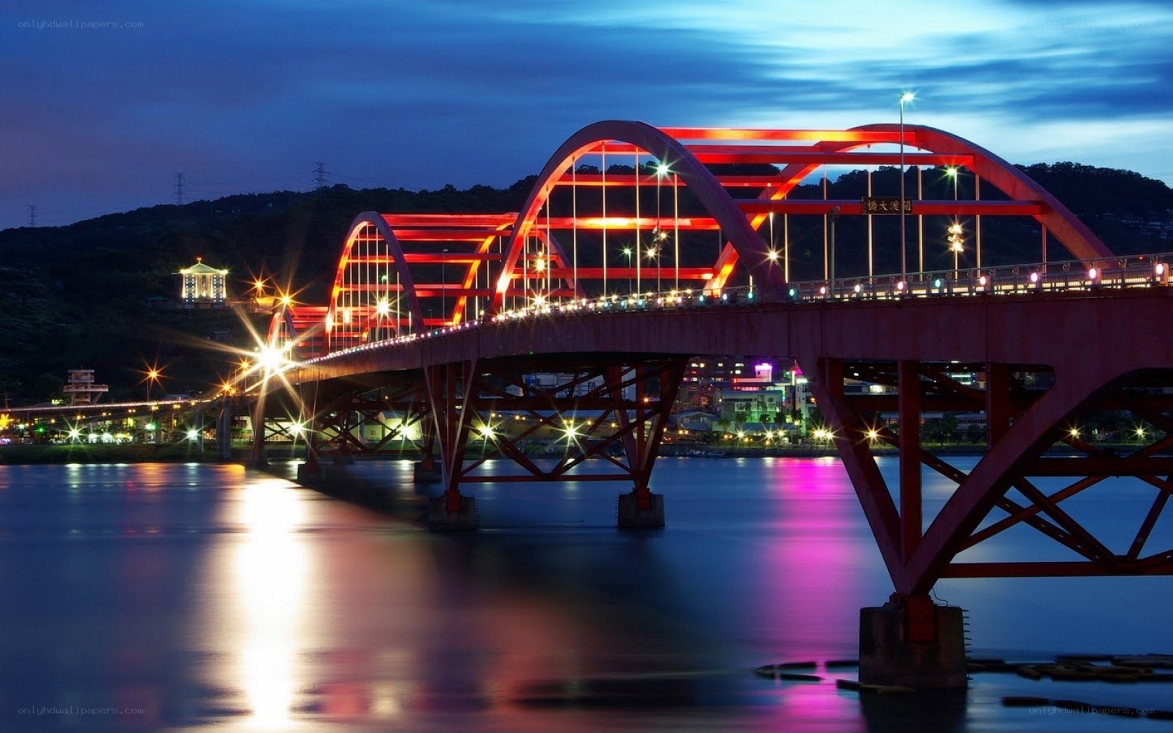 Red bridge at night over water