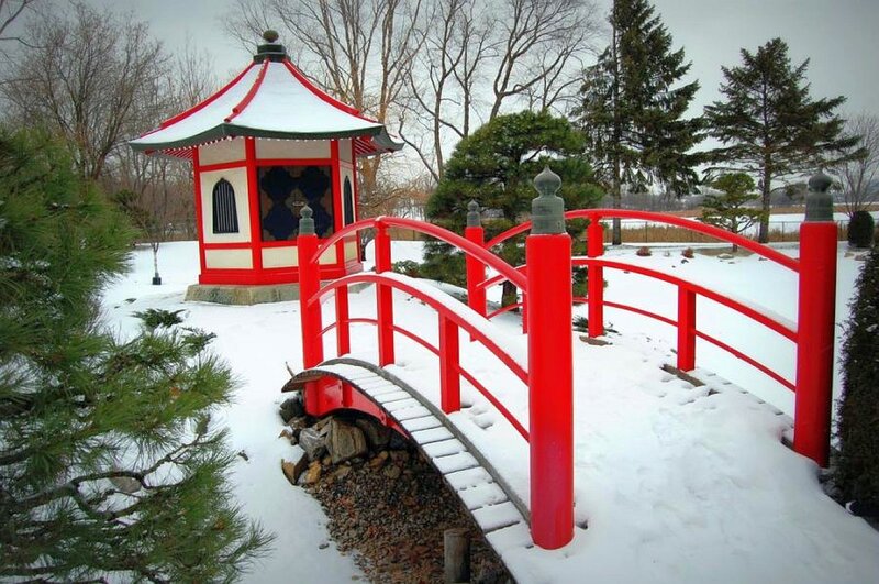 Red bridge in snowy garden
