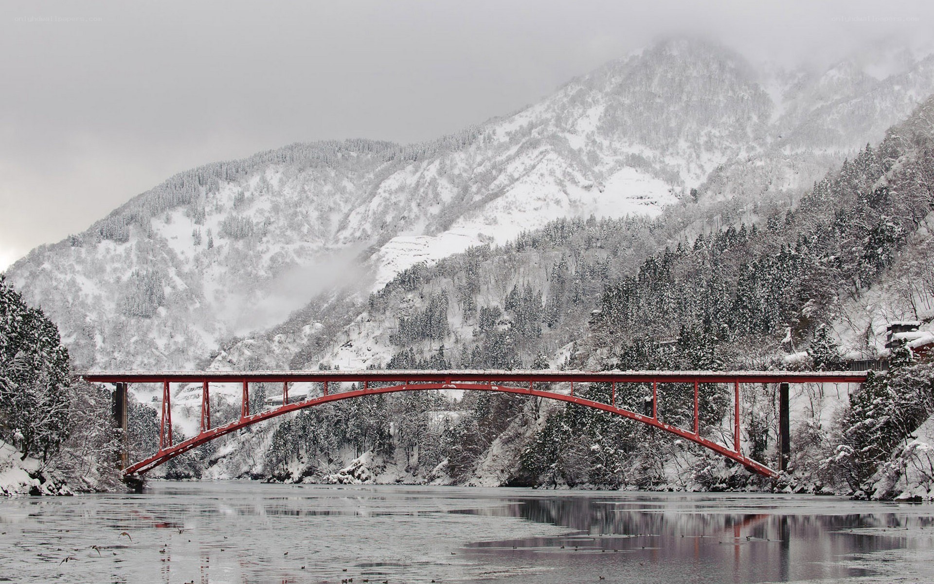 Red bridge in snowy mountains