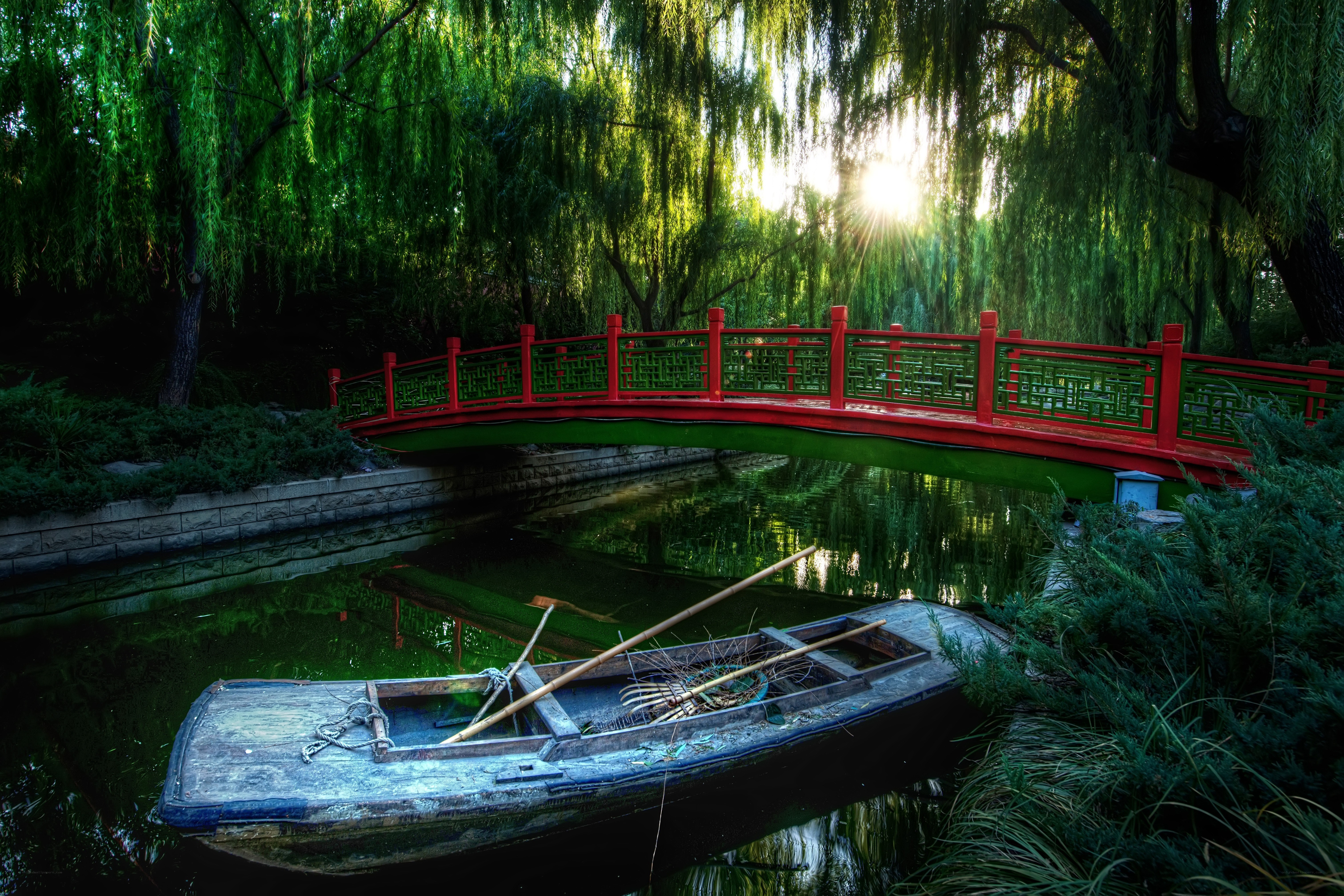 Red bridge over a tranquil pond