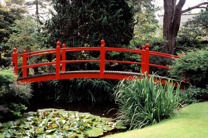Red bridge over pond in garden