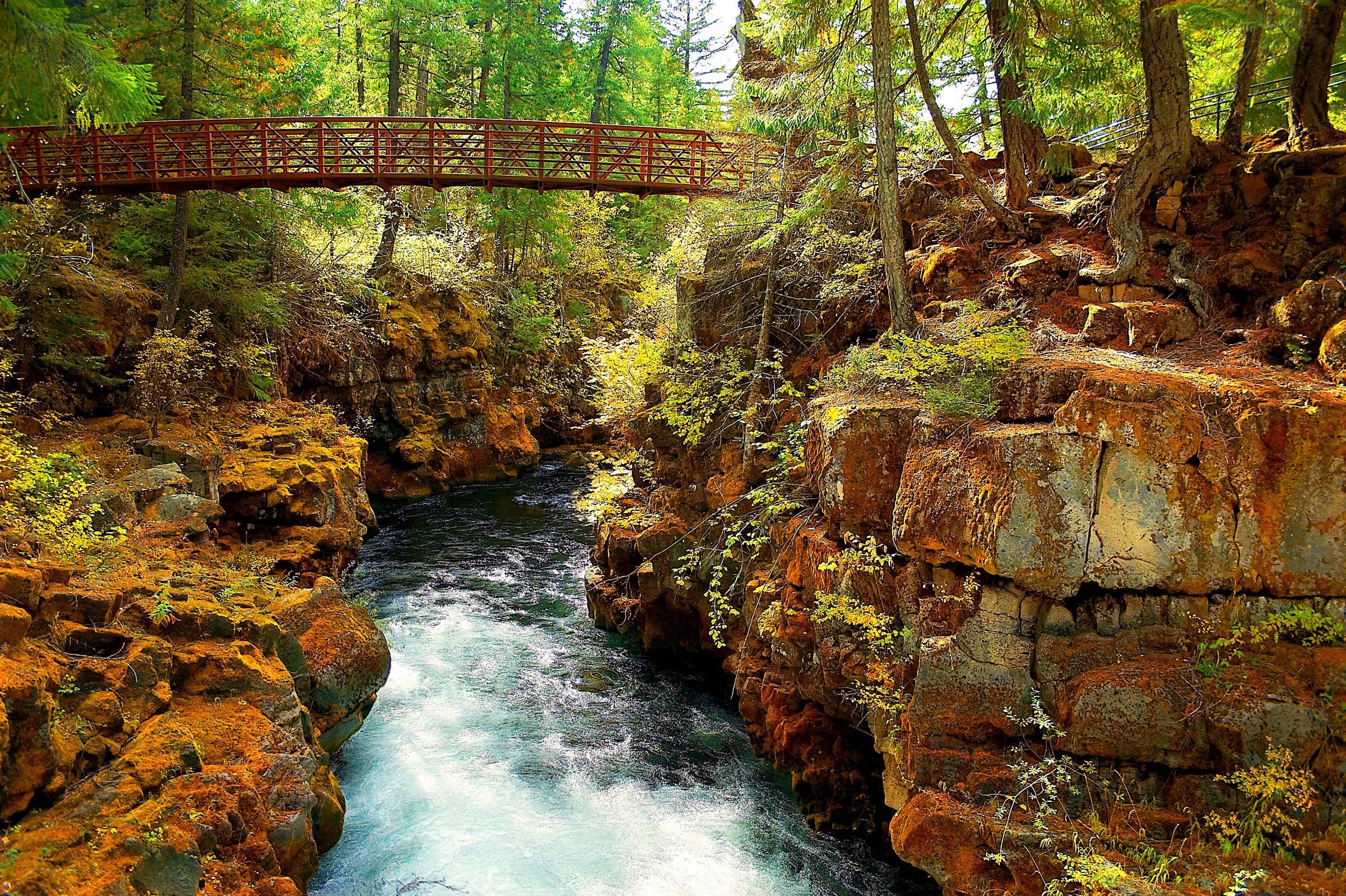 Red bridge over river canyon