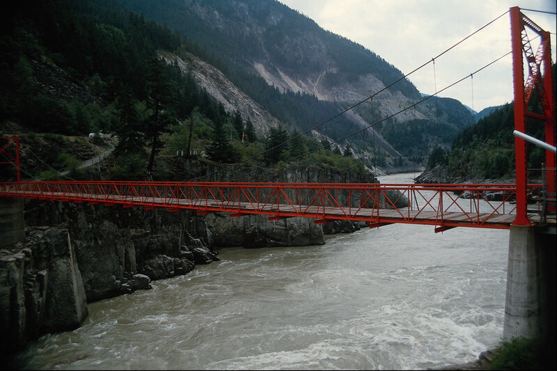 Red bridge over river in mountains