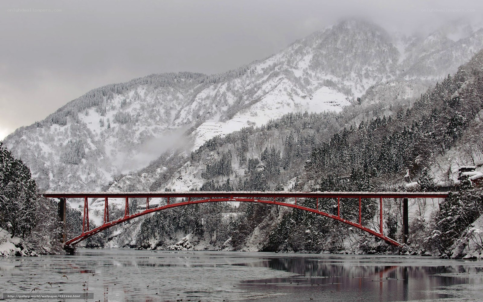 Red bridge over snowy river