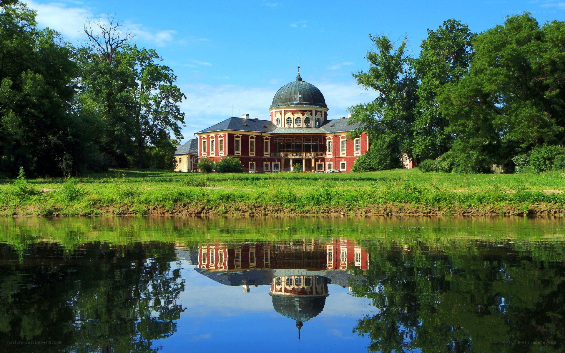 Red building with dome by river