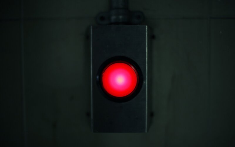 red button on dark wall