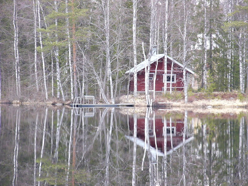 Red cabin by a lake