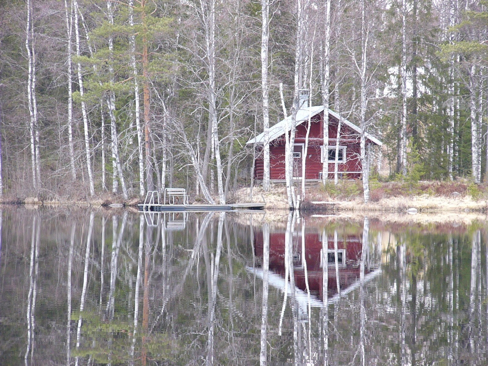 Red cabin by a lake