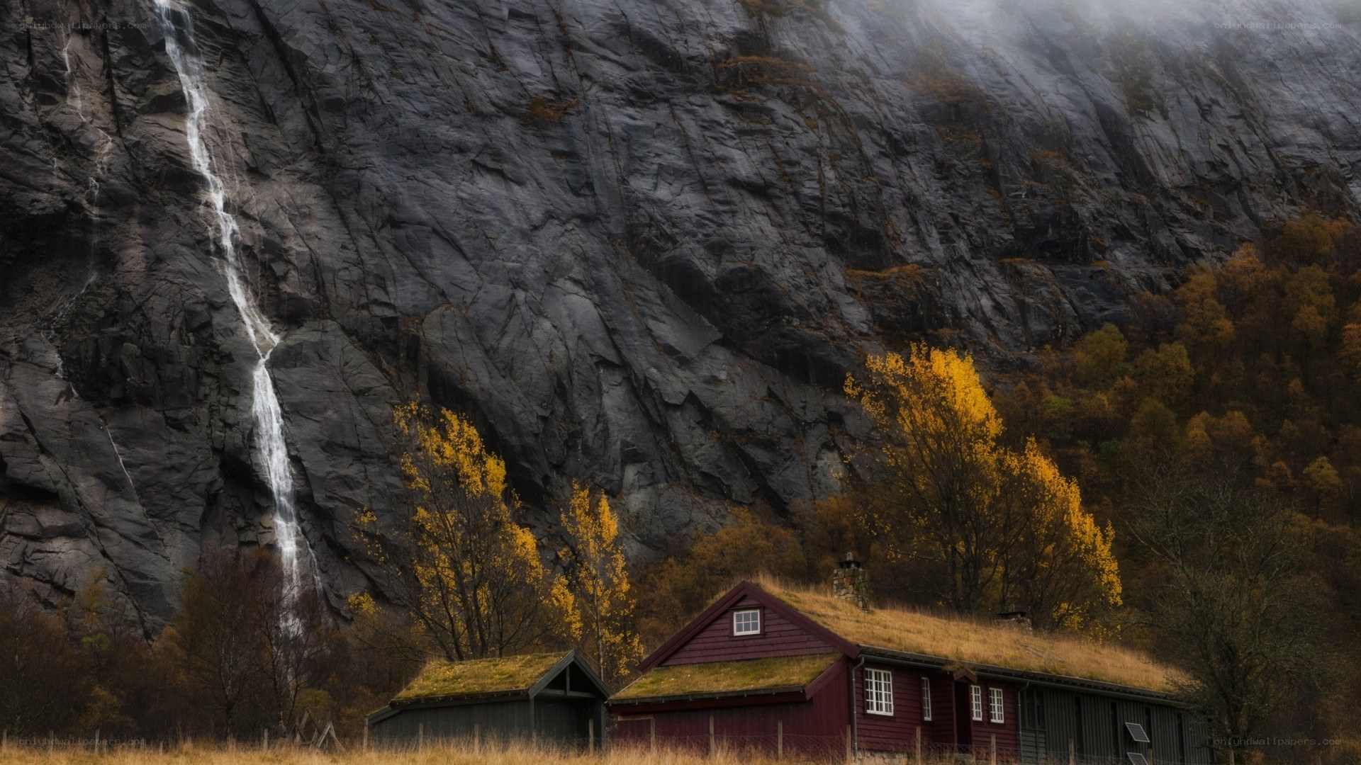 Red cabin by waterfall