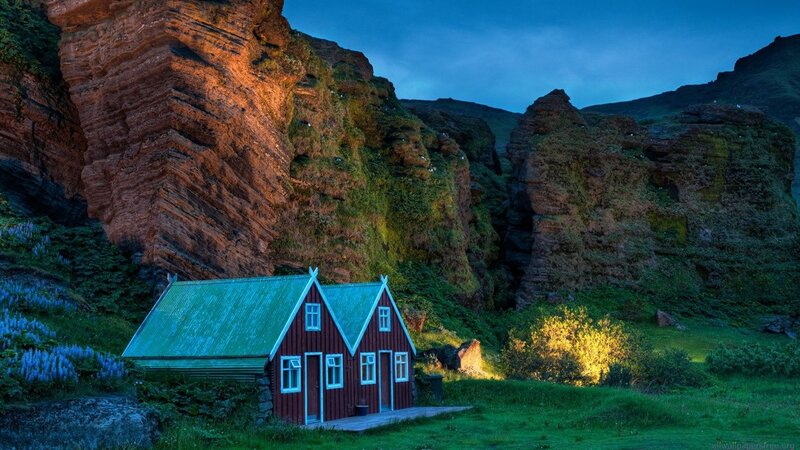 Red cabin in mountain valley