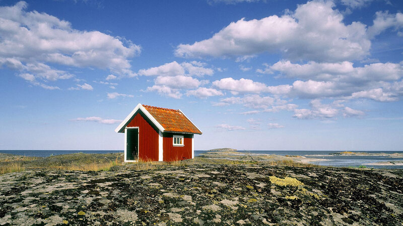 Red cabin on rocky shore