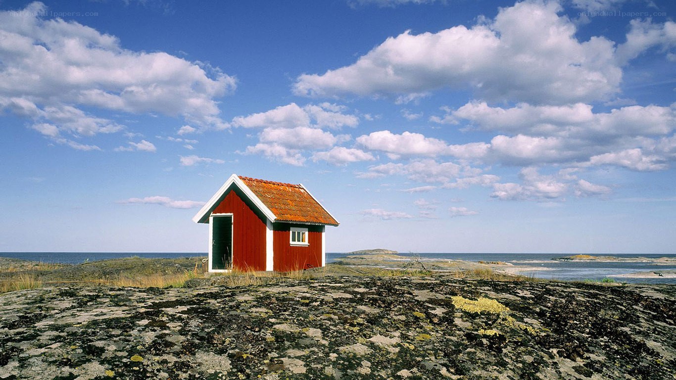 Red cabin on rocky shore
