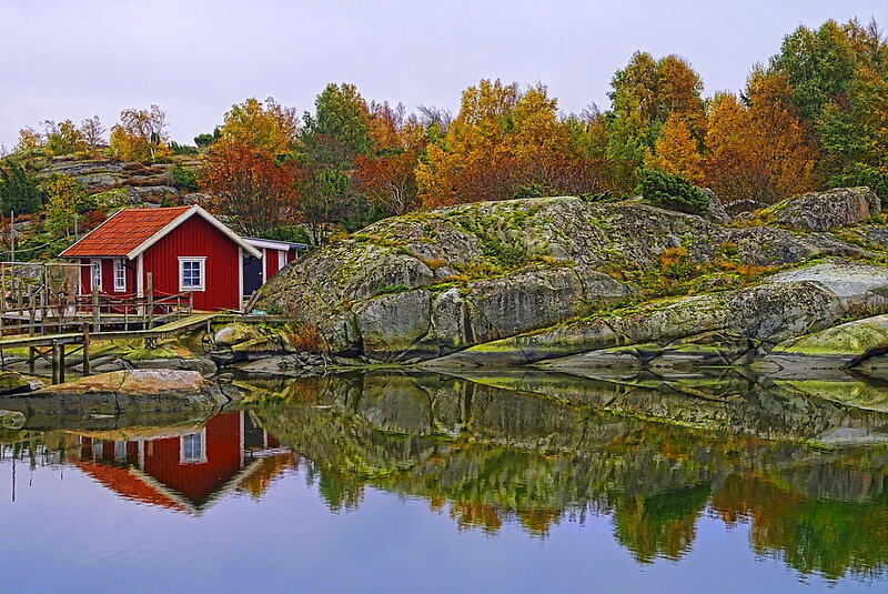 Red Cabin on Rocky Shore — Serene