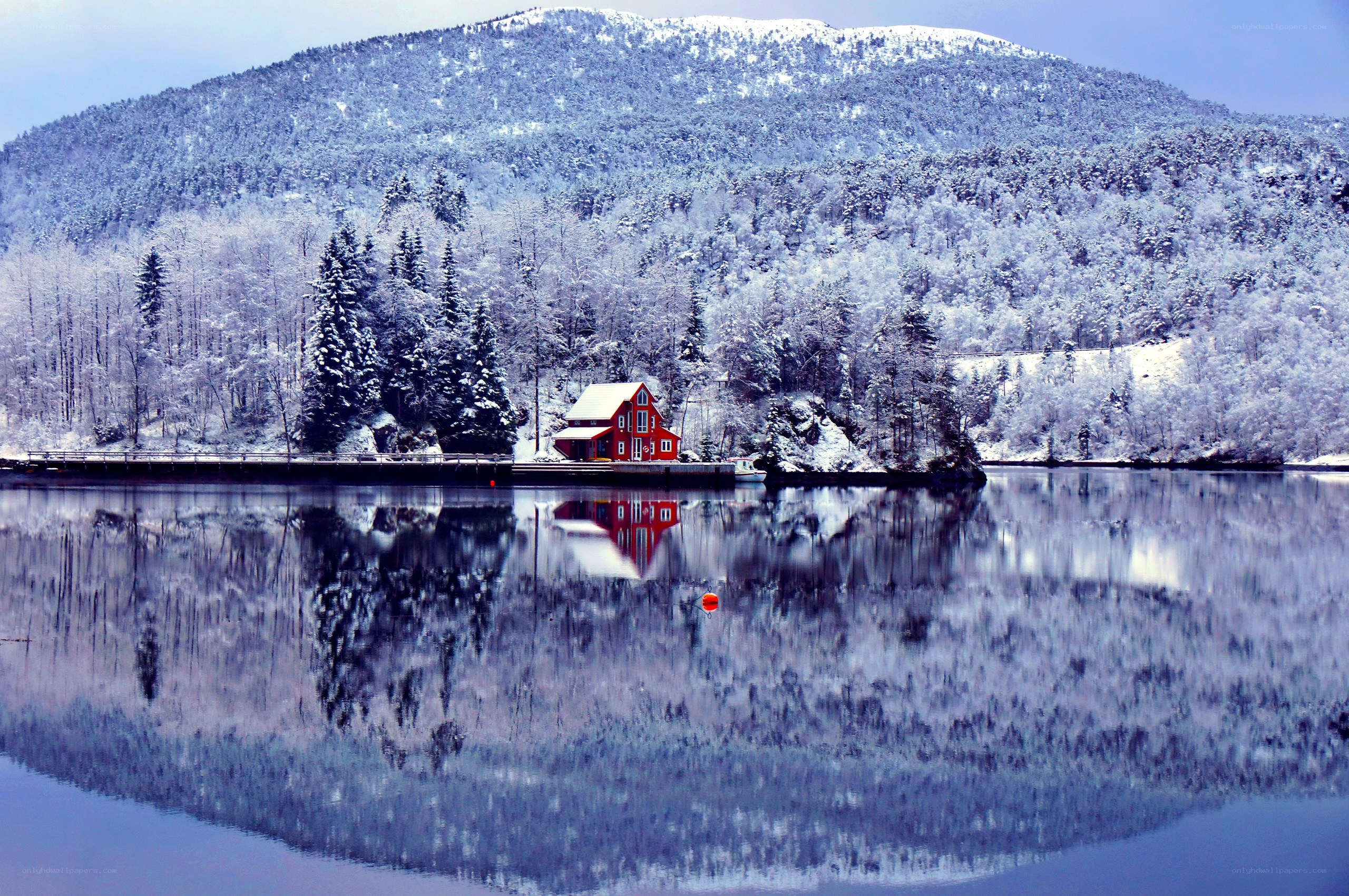 Red cabin on snowy lake
