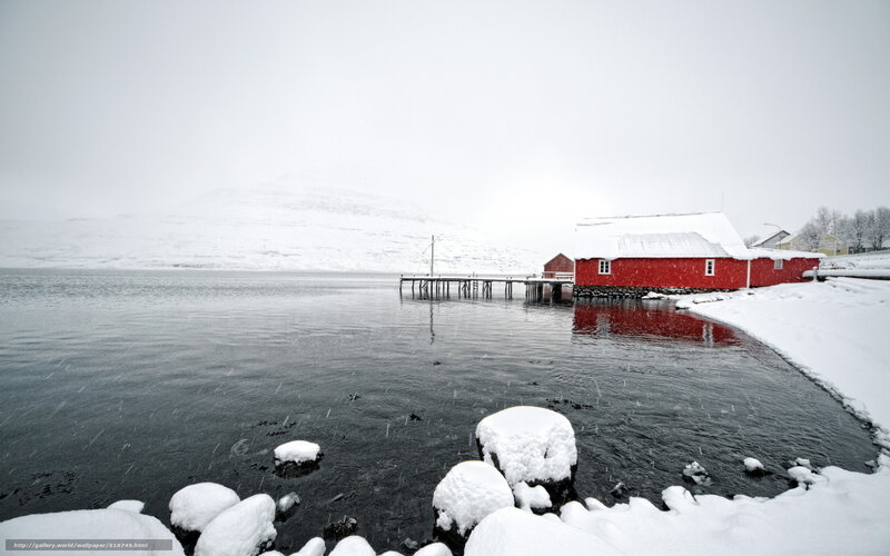 Red cabin on snowy shore