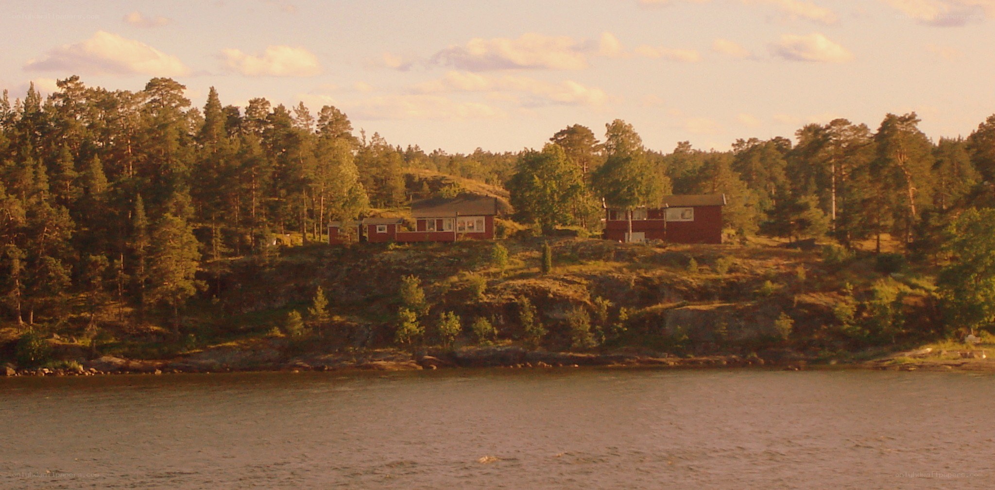 Red cabins on a forested shore