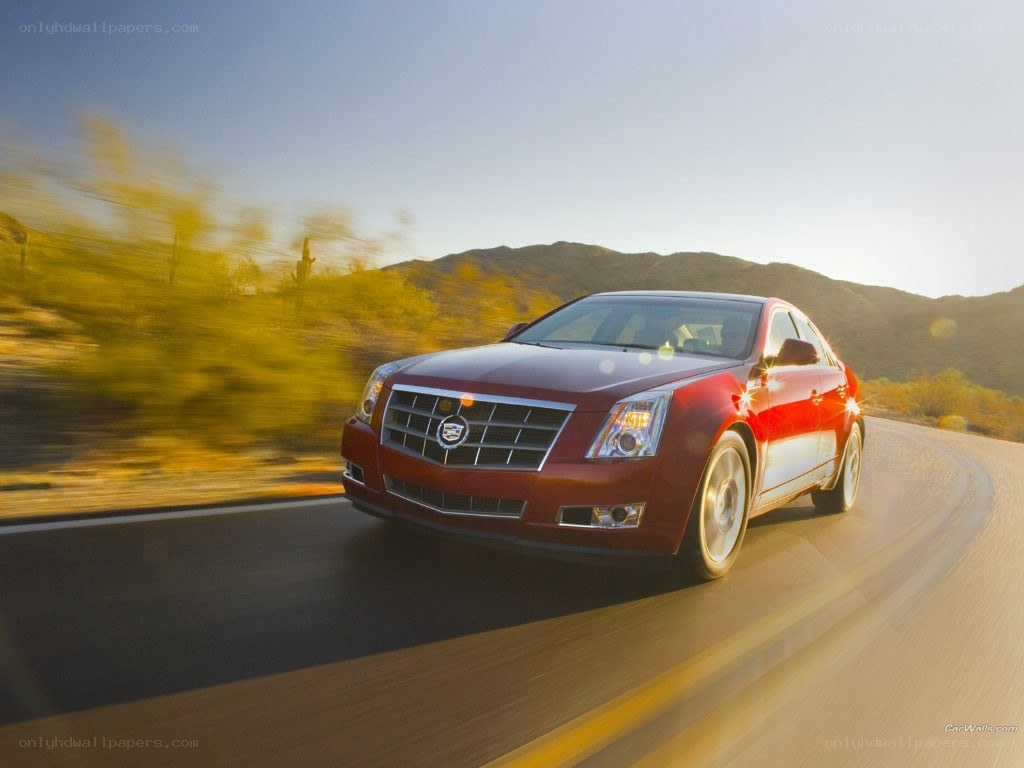Red Cadillac driving on a road