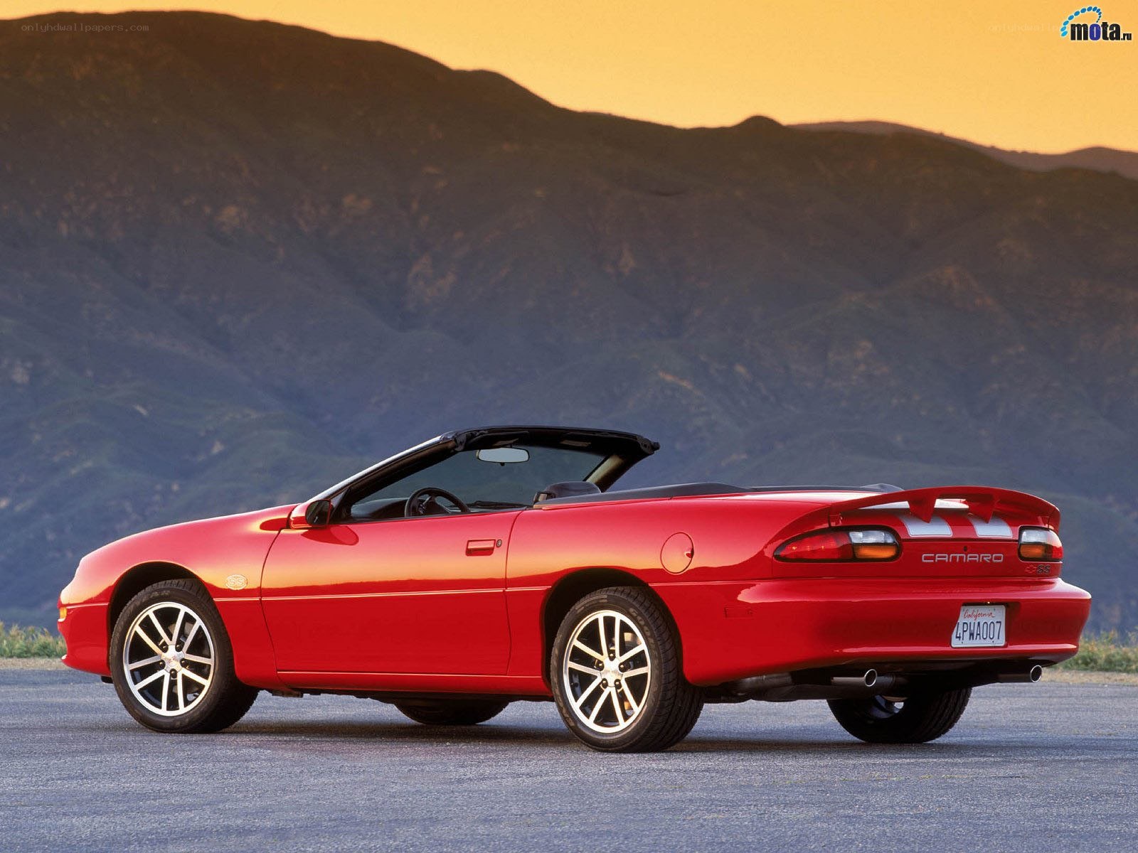 Red Camaro convertible at sunset