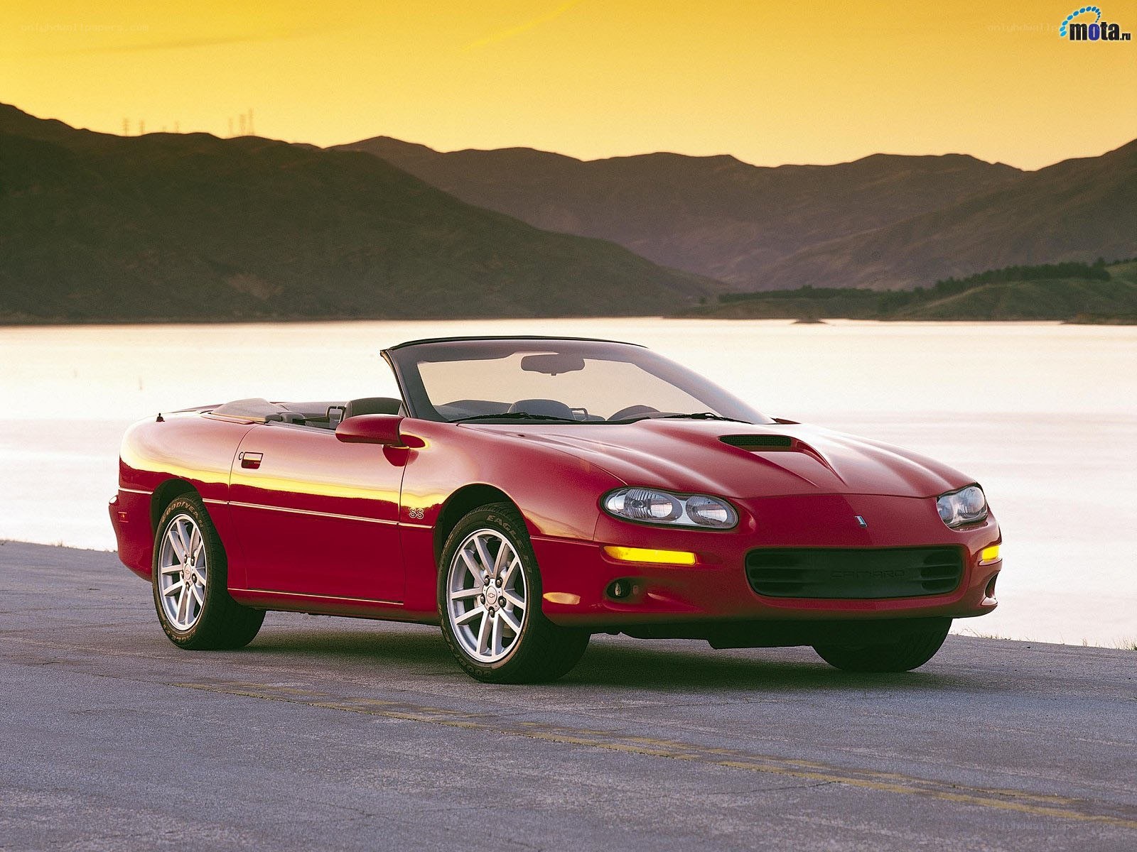 Red Camaro convertible by lake