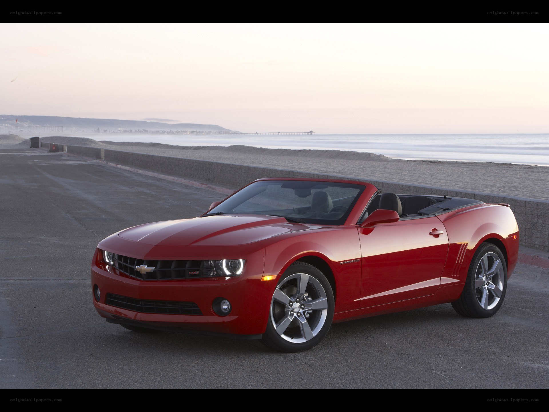 Red Camaro convertible on beach