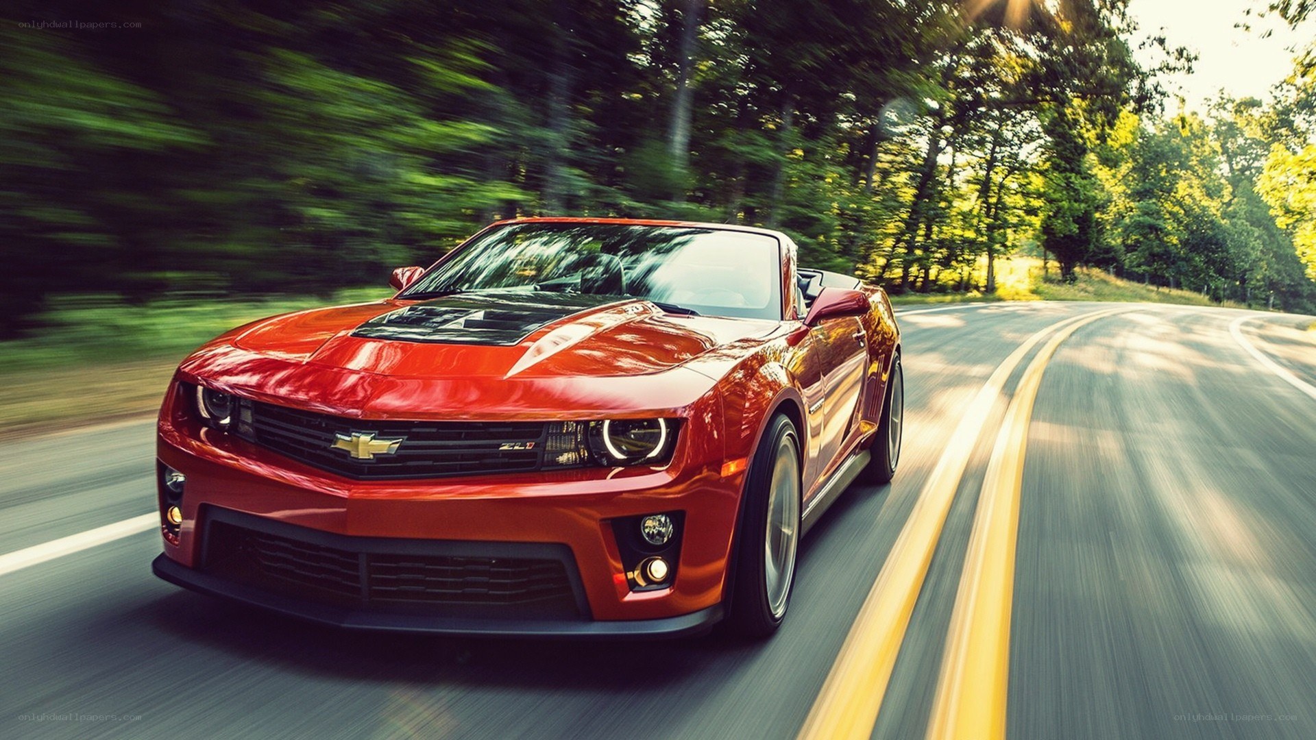Red Camaro convertible on road
