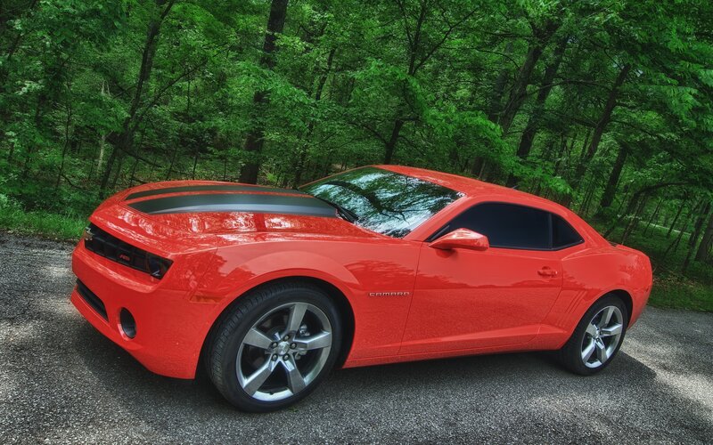 Red Camaro in forest setting