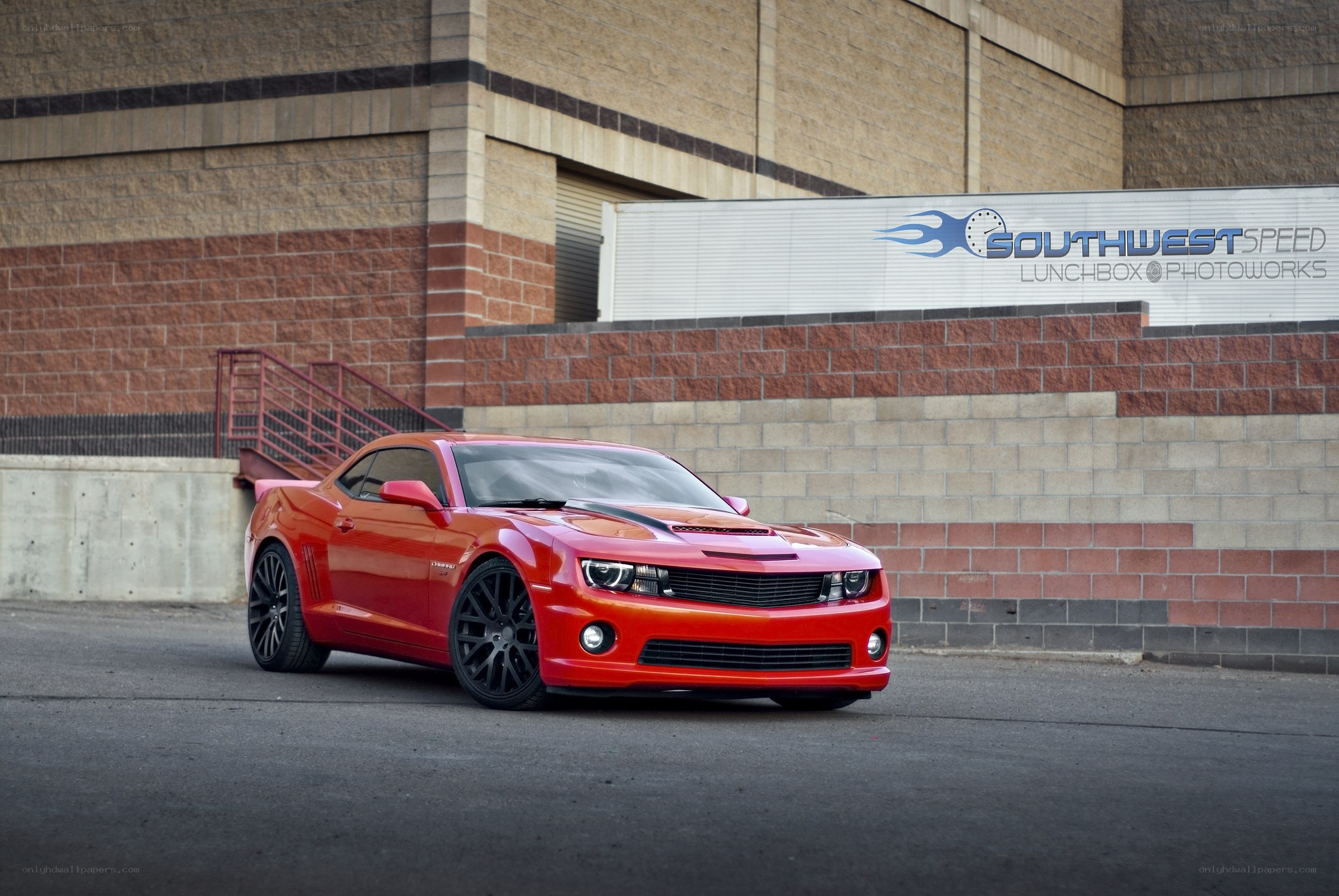 Red Camaro in front of building