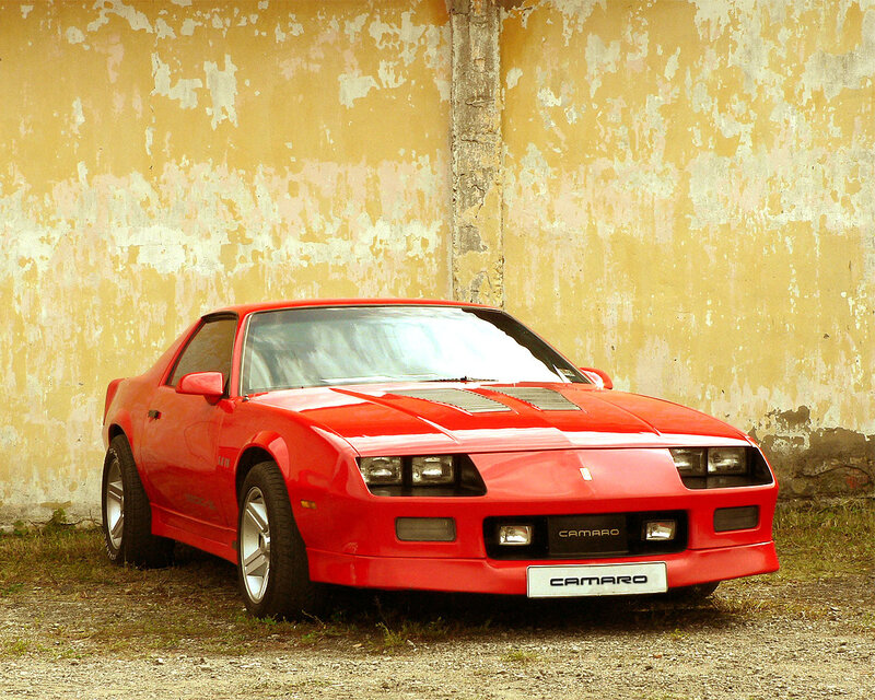 Red Camaro in front of old wall