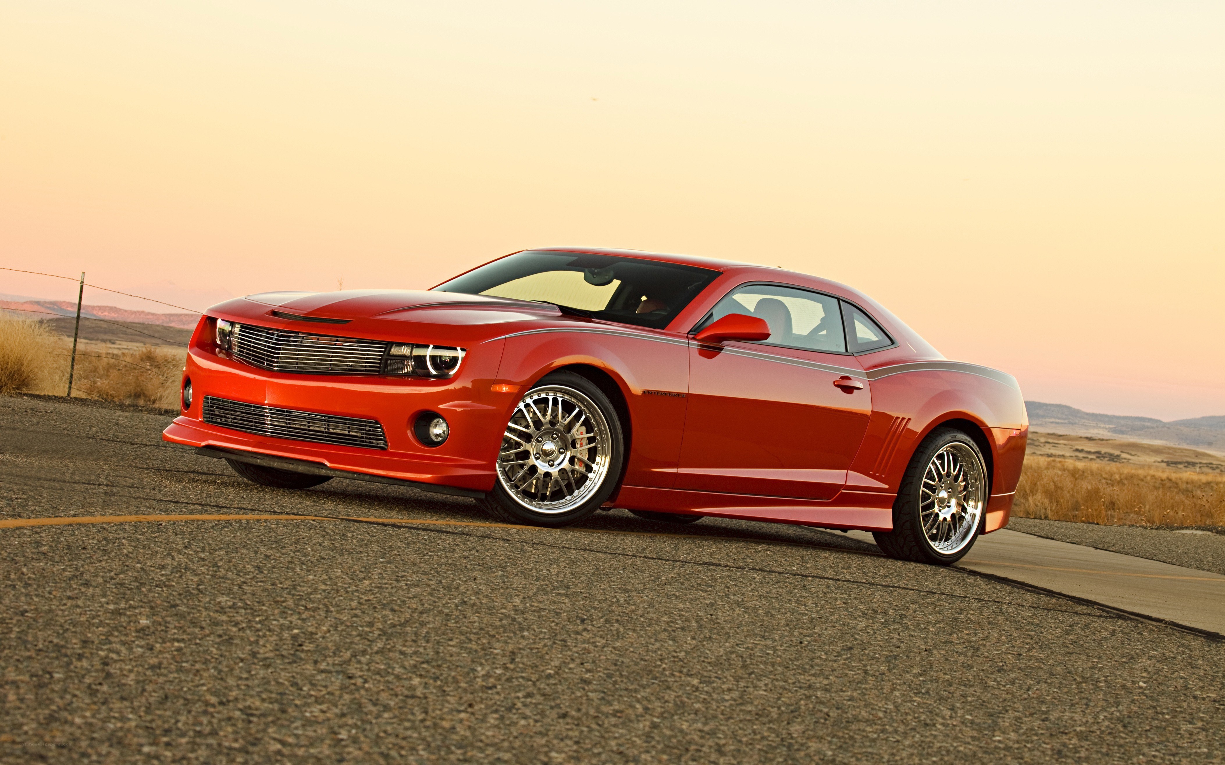 Red Camaro on a desert road