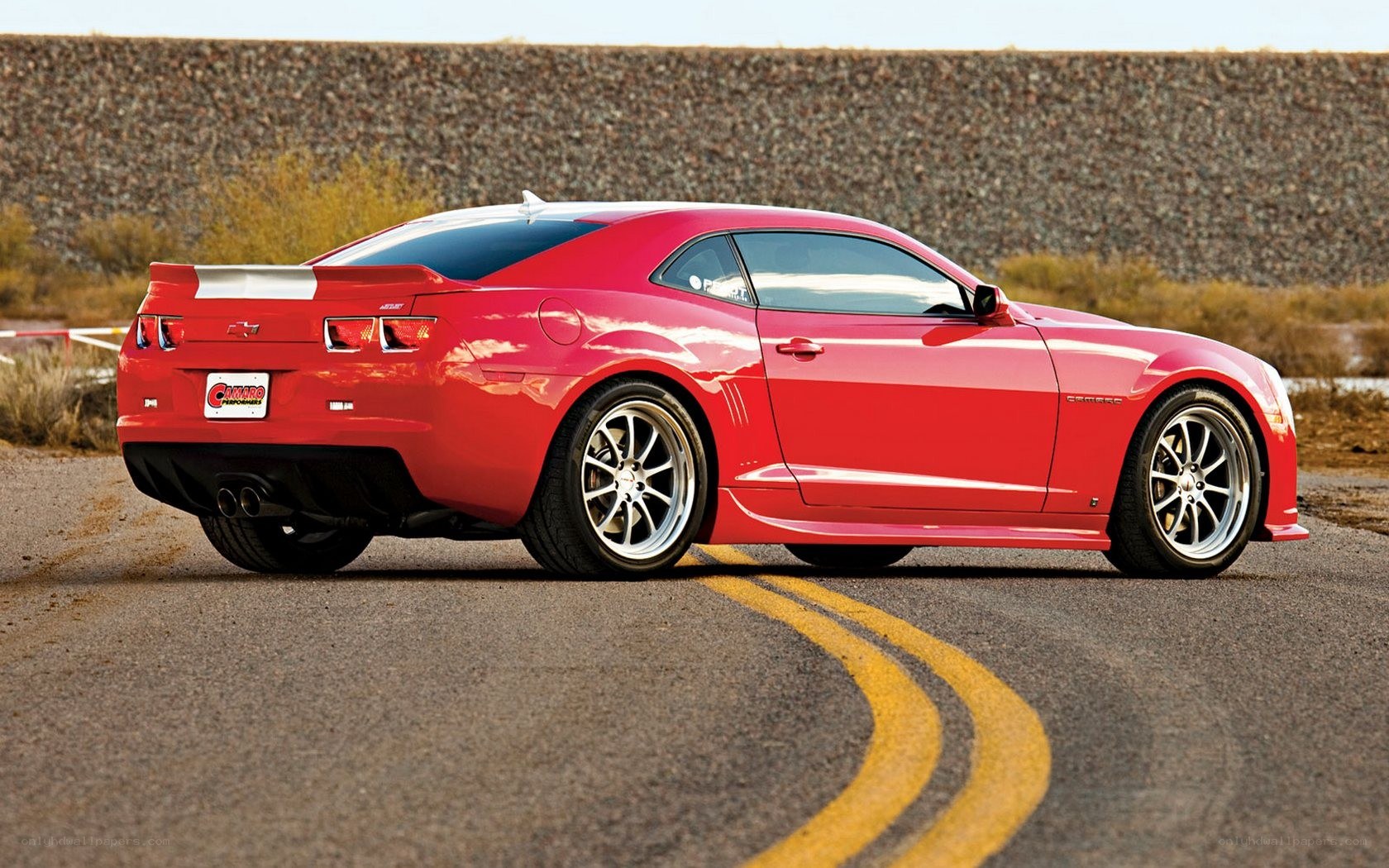 Red Camaro on a winding road