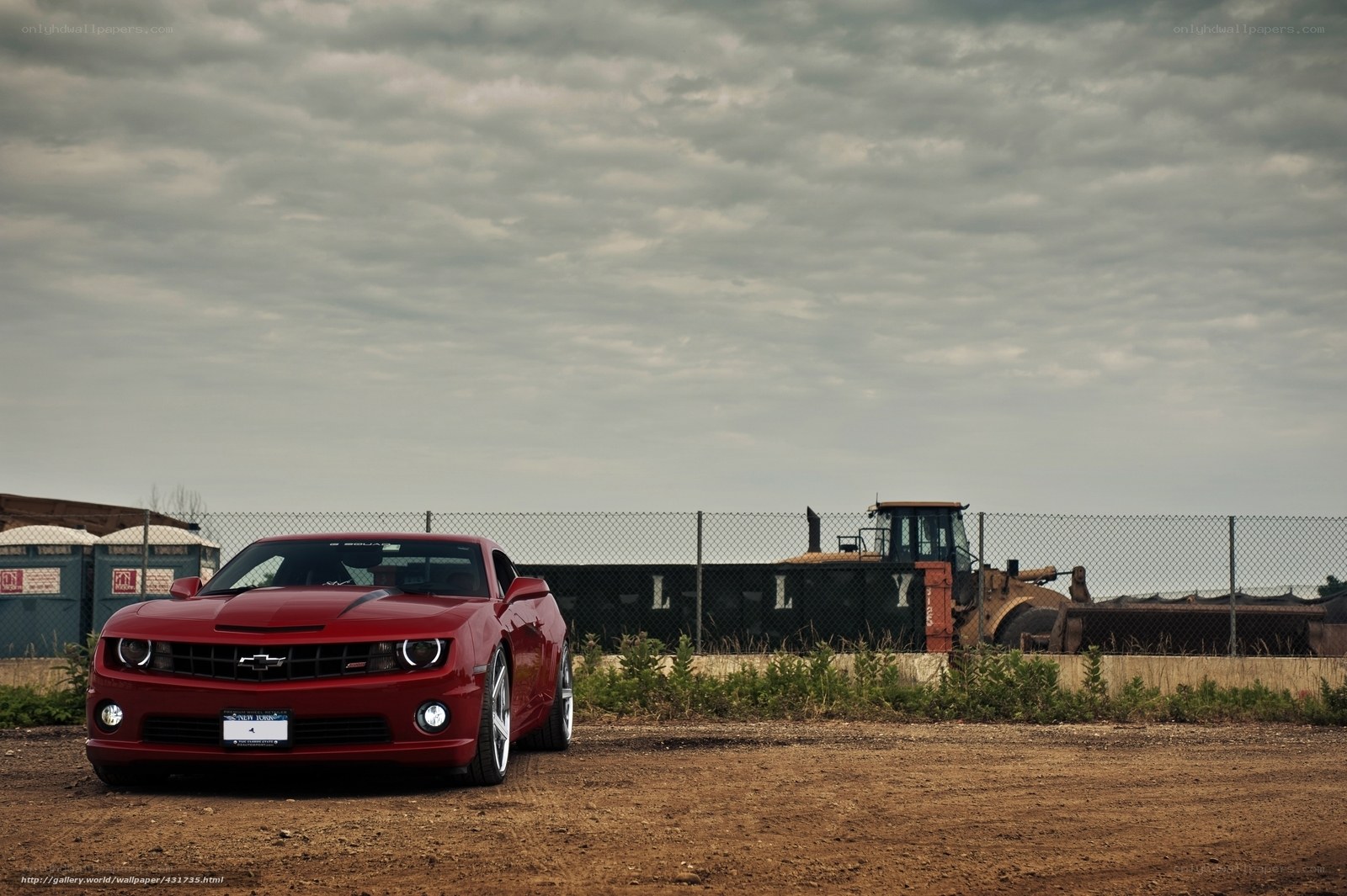 Red Camaro on dirt lot