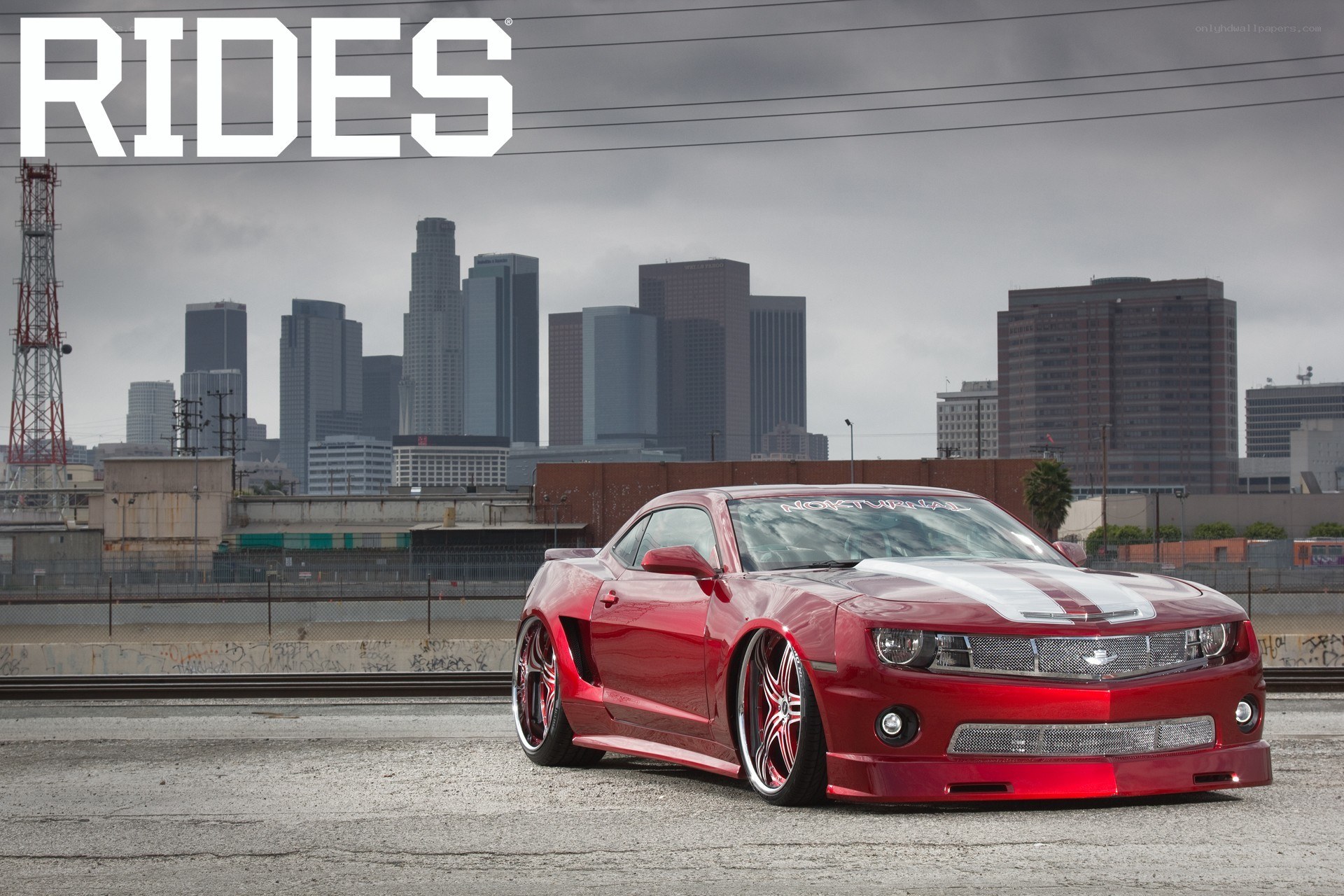 Red Camaro with city skyline