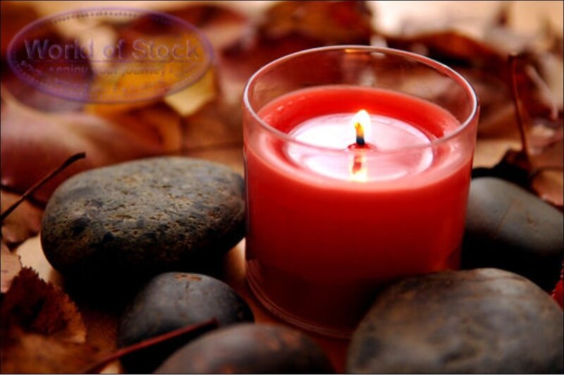 Red candle with autumn leaves