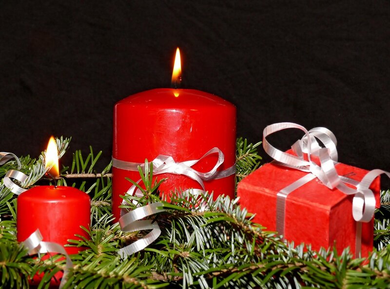Red candles and gifts on fir branches