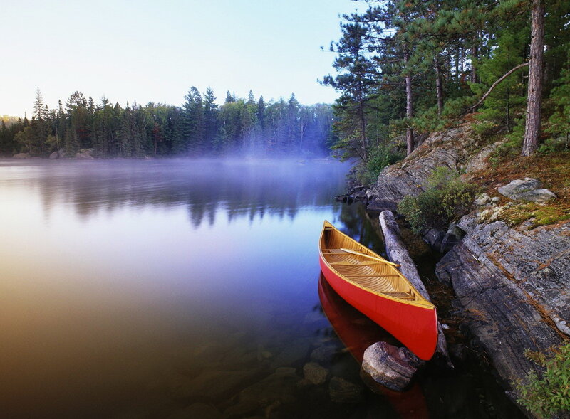 Red canoe on misty lake