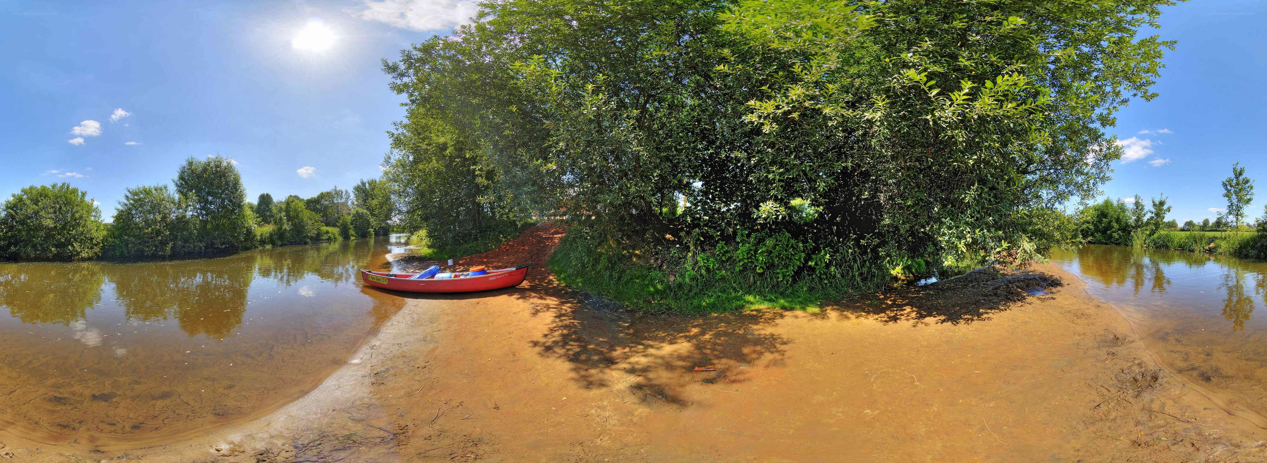 Red canoe on riverbank