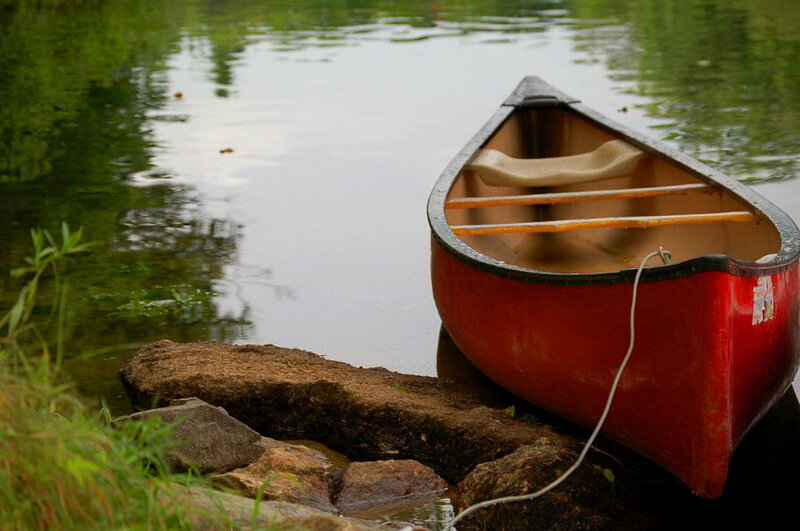 Red Canoe on Riverbank — Serene