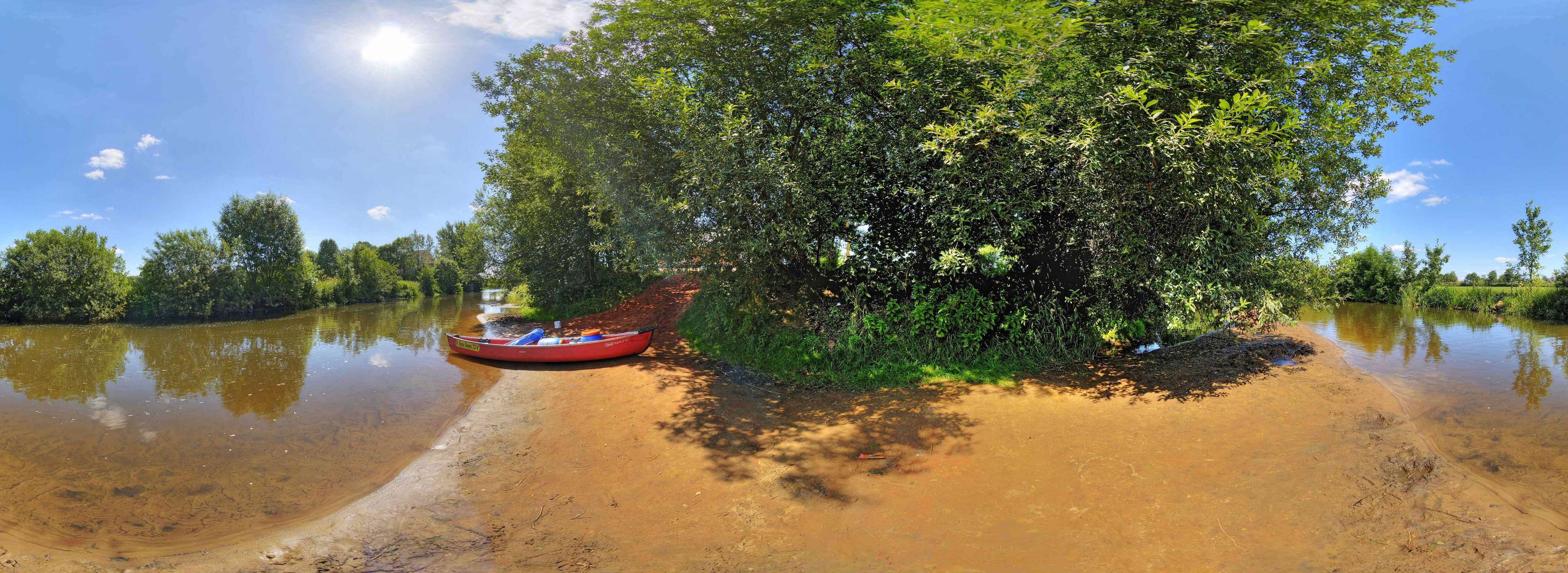 Red canoe on riverbank