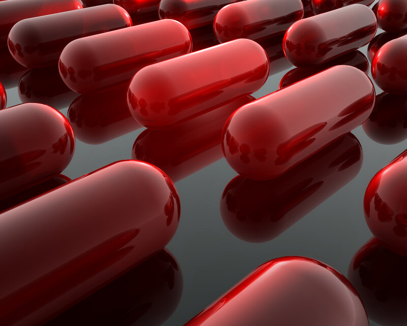 Red capsules on reflective surface