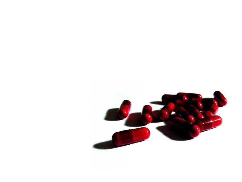 red capsules on white surface