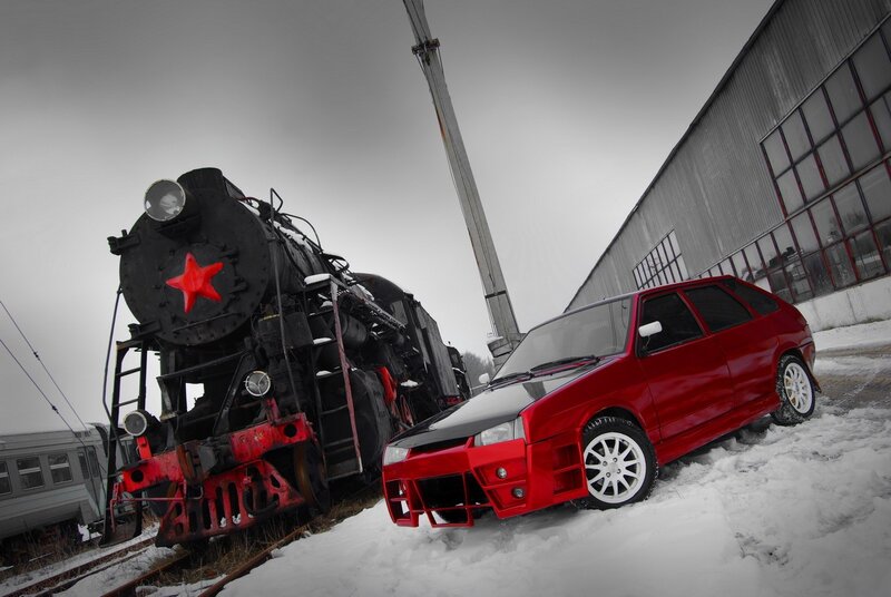 Red car and steam train in snow