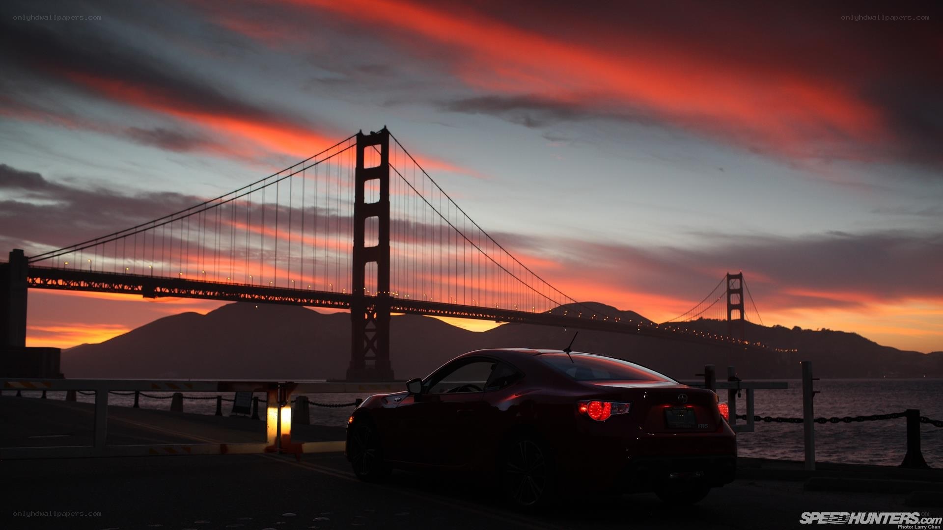 Red car at Golden Gate Bridge sunset