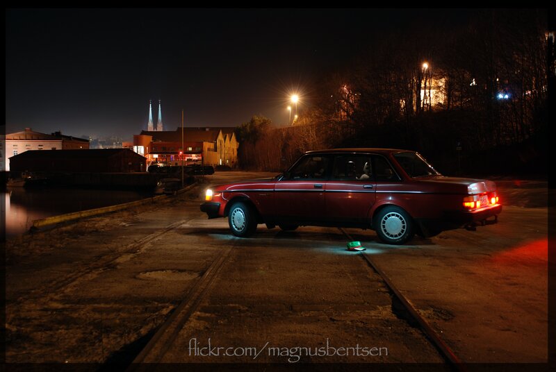 Red car at night by the water