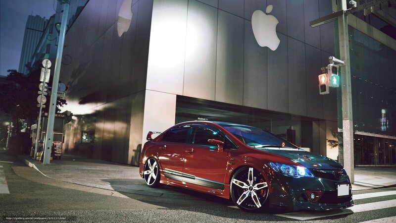 Red car at night near Apple store