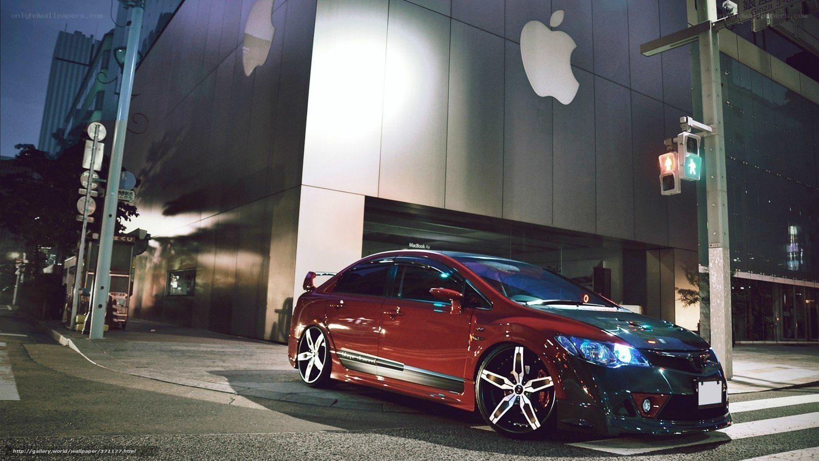 Red car at night near Apple store